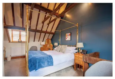 a bedroom with a canopy bed and a desk at Sebastians in Oswestry