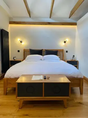 a bedroom with a large bed with a wooden table at Sebastians in Oswestry