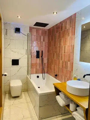 a bathroom with a tub and a toilet and a sink at Sebastians in Oswestry