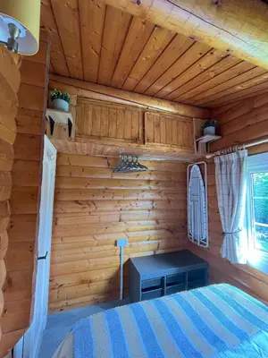 a room in a log cabin with a bed and a window at Log Cabin Retreat Snowdonia in Trawsfynydd