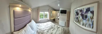 a bedroom with a large bed and a window at Harries Superior Lodge Ocean in New Quay