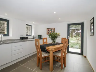 a kitchen with a wooden table and chairs in a kitchen at The Barn in Bishops Castle