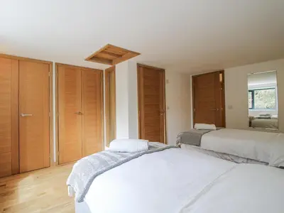 a bedroom with two beds and wooden cabinets at The Barn in Bishops Castle