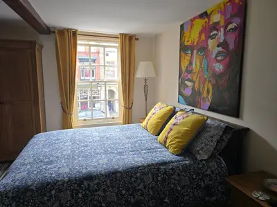 a bedroom with a bed with a painting on the wall at Family Room - The Unicorn Hotel in Llanidloes