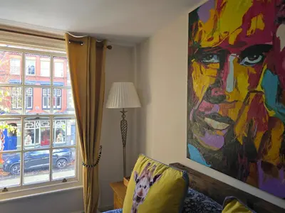 a painting on the wall of a room with a couch and a window at Family Room - The Unicorn Hotel in Llanidloes