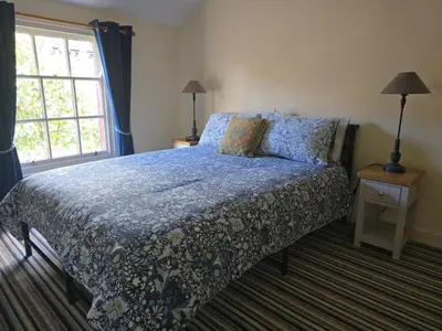 a bedroom with a bed with a blue comforter and a window at Cozy Double Room - The Unicorn Hotel in Llanidloes