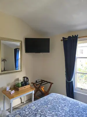 a bedroom with a bed and a television on the wall at Cozy Double Room - The Unicorn Hotel in Llanidloes