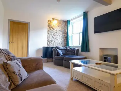 a living room with a couch and a coffee table at Preesgweene Farmhouse in Oswestry