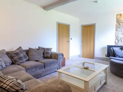 a living room with a couch and a coffee table at Preesgweene Farmhouse in Oswestry