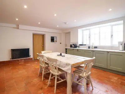 a kitchen with a table and chairs in a room at Preesgweene Farmhouse in Oswestry
