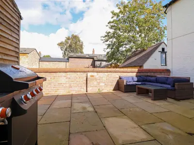 a backyard patio with a couch and a table at Preesgweene Farmhouse in Oswestry
