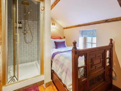 a bedroom with a bed and a shower at Rustic Retreat in Llangadog