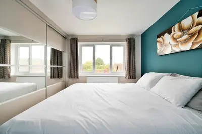 a bedroom with a large white bed and two windows at Finest Retreats - Elizabeth House in Kington