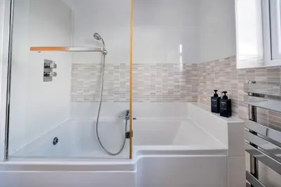 a bath tub with a shower in a bathroom at Finest Retreats - Elizabeth House in Kington