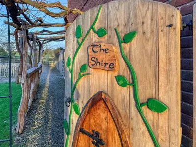a wooden door with a sign that reads the shire at Shires End in Leominster