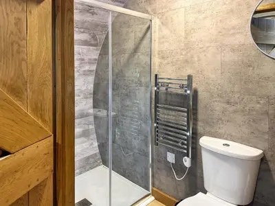 a bathroom with a toilet and a glass shower at Shires End in Leominster