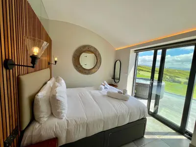 a bedroom with a large bed with a large window at The Willow Hill in Aberdyfi