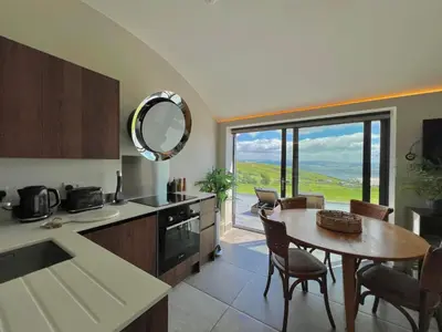a kitchen and dining room with a table and a window at The Willow Hill in Aberdyfi