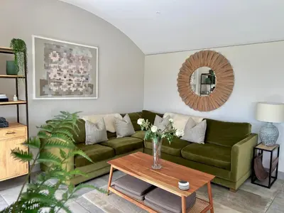 a living room with a green couch and a table at The Willow Hill in Aberdyfi