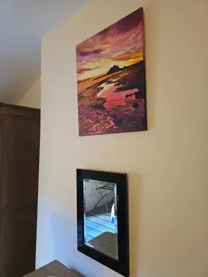 a mirror on a wall with a painting above it at Honeymoon Suite - The Unicorn Hotel in Llanidloes