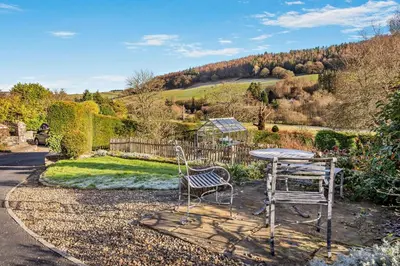 a table and two chairs sitting in a garden at 3 Bed in Defynnog oc-p33133 in Devynock