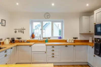 a kitchen with white cabinets and a clock on the wall at 4 Bed in Llanigon oc-t33091 in Llanigon