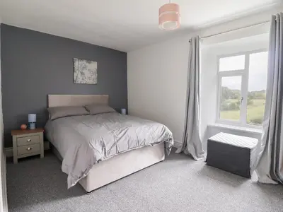 a bedroom with a bed and a window at Plas Yn Bonwm in Corwen