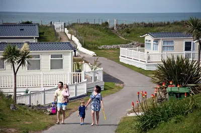 a family walking down a road in front of houses at Barmouth Bay Holiday Park in Barmouth