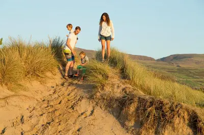 a group of people standing on a sand hill at Barmouth Bay Holiday Park in Barmouth