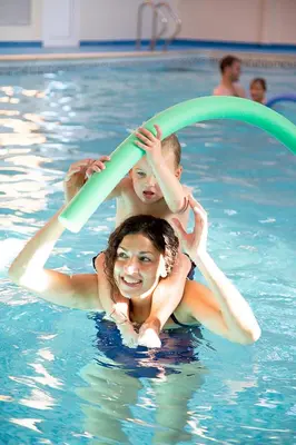 a woman and two children are in a swimming pool at Barmouth Bay Holiday Park in Barmouth
