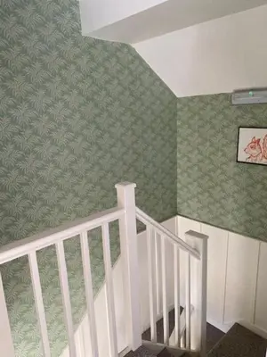 a staircase in a room with green wallpaper at Charming cottage in central Ludlow with parking in Ludlow