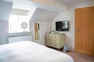 a bedroom with a bed and a tv on the wall at Charming cottage in central Ludlow with parking in Ludlow