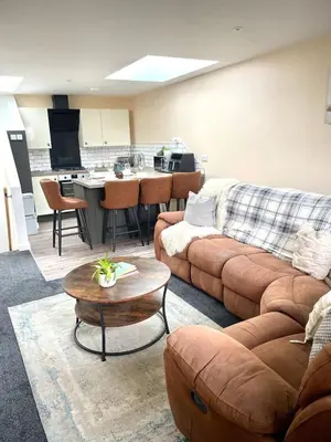 a living room with a couch and a kitchen at Modern 1 Bed Apartment Sleeps 2 in Llanbadarn-fawr