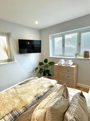 a bedroom with a bed and a tv on the wall at Modern 1 Bed Apartment Sleeps 2 in Llanbadarn-fawr