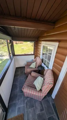 a screened in porch with two couches and a table at Eryri Retreat in Trawsfynydd