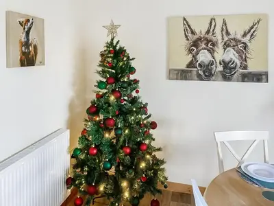 a christmas tree in a living room with two horses at Cothi Cottage - Uk49588 in Llansawel
