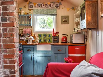 a small kitchen with blue cabinets and a sink at The Cabin in Llangadog