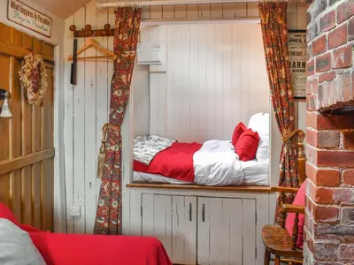 a room with a small bed in a house at The Cabin in Llangadog