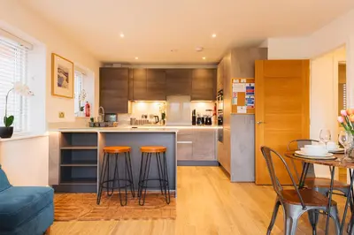 a kitchen with a counter and stools in a room at 2 Bedroom Apartment - Parking - Walk to Town in Shrewsbury