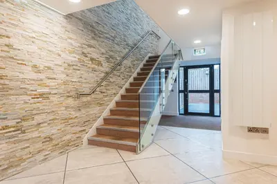 a lobby with a staircase and a brick wall at 2 Bedroom Apartment - Parking - Walk to Town in Shrewsbury