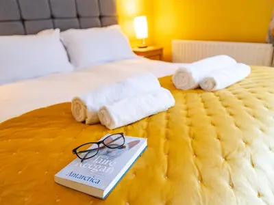 a bed with towels and a book and glasses at Pass the Keys Charming 2 Bed Townhouse Short Walk To The River in Shrewsbury