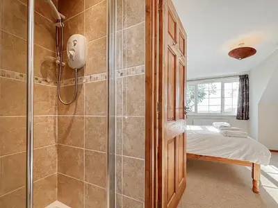 a bathroom with a shower and a bed in a room at Brithdir in Welshpool