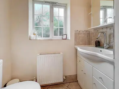a bathroom with a sink and a toilet and a window at Brithdir in Welshpool