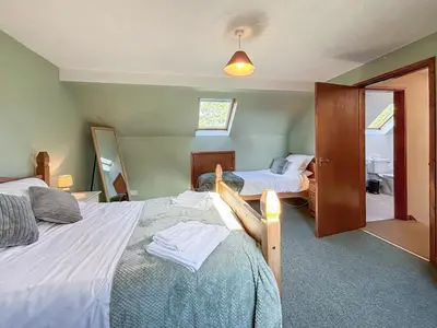 a bedroom with two beds and a mirror at Brithdir in Welshpool