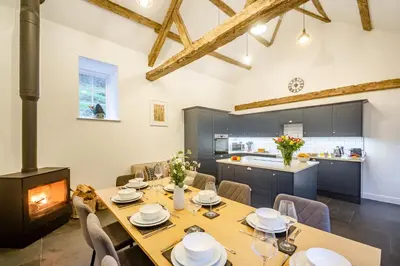 a kitchen and dining room with a table and a fireplace at Luxury Cottage near Dolgellau in Llanfachreth