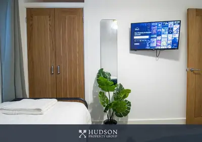 a bedroom with a bed and a tv on a wall at Central Oswestry 2 Bedroom House in Oswestry