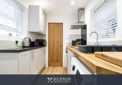 a kitchen with white cabinets and a sink at Central Oswestry 2 Bedroom House in Oswestry
