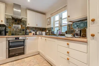 a kitchen with white cabinets and a stove top oven at 2 Bed in Weobley oc-c32945 in Weobley