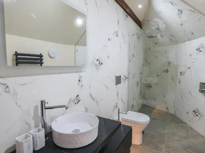 a bathroom with a toilet and a sink and a mirror at Y Cwlwm - The Celtic Knot in Lampeter