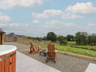 two chairs and a bench on a patio with a garden at Yr Awen - Inspiration in Lampeter